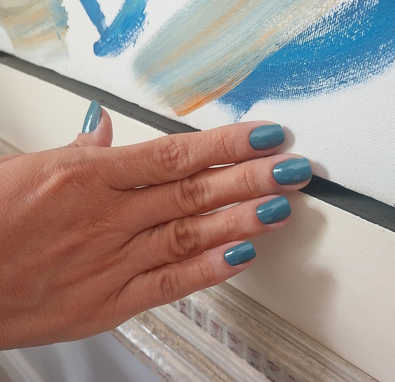 Manicure com esmalte azul petróleo feita pelo Espaço Luci